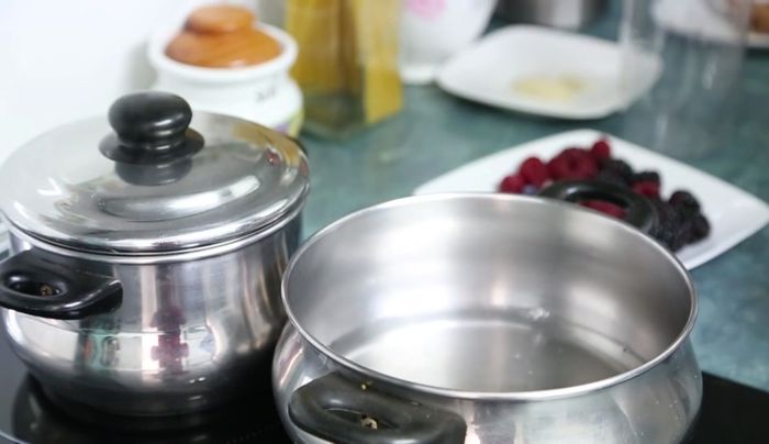 Preparar un almíbar ligero con el doble de azúcar que de agua y las frutas rojas restantes.