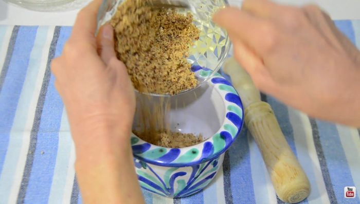 Mientras tanto, triturar las almendras en un procesador de alimentos. En un mortero, mezclar las almendras trituradas con las dos yemas de huevo y el resto del vino blanco hasta obtener una pasta homogénea.