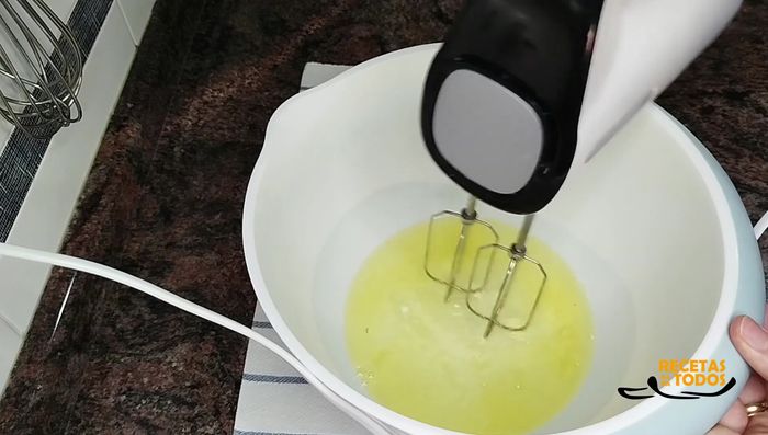Agregar algo más de la mitad del azúcar (250g) a las claras batidas y seguir batiendo hasta formar picos.