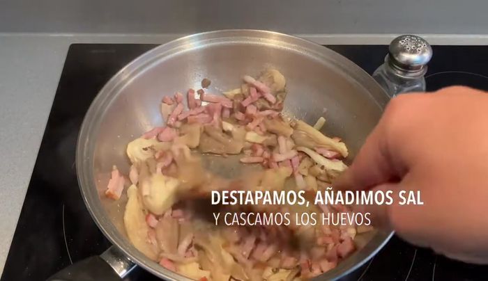 Cuando las setas estén listas, añadir un poco de sal y los huevos a la sartén. Remover.