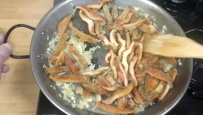 Agregamos los níscalos, subimos el fuego al máximo, añadimos sal y cocinamos 4-5 minutos hasta que suelten el agua.