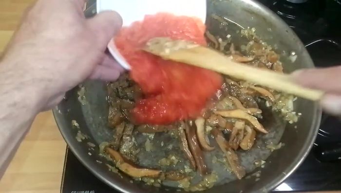 Añadimos el tomate rallado, mezclamos bien y cocinamos hasta que se evapore el agua.