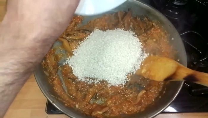 Añadimos el arroz, removemos para mezclarlo con los demás ingredientes y cocinamos 2 minutos.