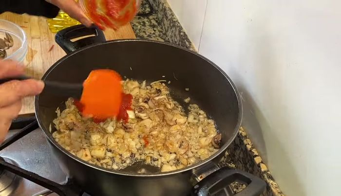 Incorporar la salsa de tomate frita al sofrito de cebolla y sepia. Cocer a fuego lento hasta obtener una consistencia de mermelada. (259.12)