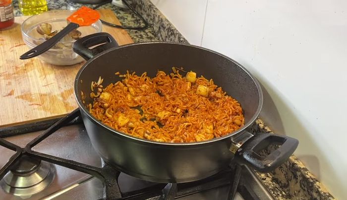 Añadir caldo de pescado caliente, sazonar con sal y pimienta al gusto, y cocinar los fideos hasta alcanzar el punto deseado. (296.919)