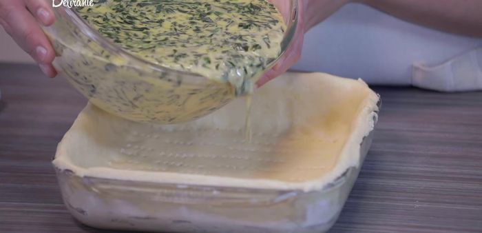 Agregar la mezcla de espinacas y cubrir con queso Manchego rallado.