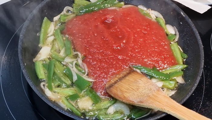 Añadir el tomate triturado natural, sal y una pizca de azúcar (o miel) para reducir la acidez. Cocinar a fuego medio durante 15 minutos. [94.92]