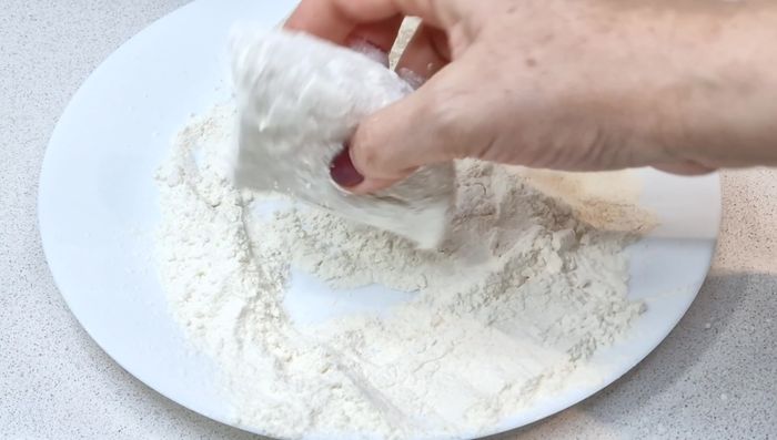Pasar los trozos de bacalao por harina, quitando el exceso. Reservar. [32.48]