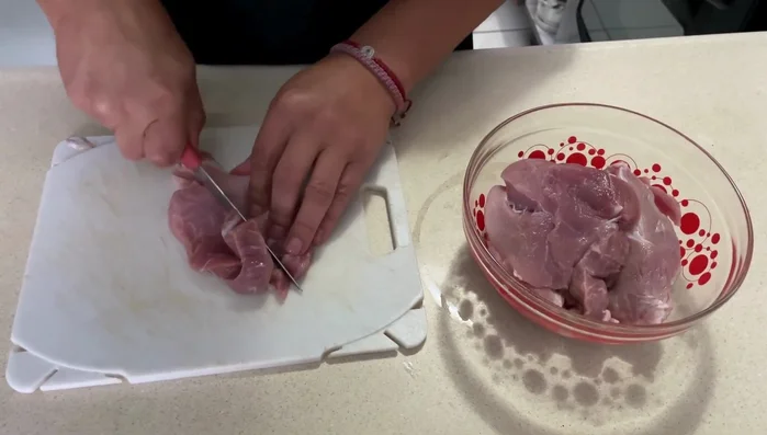 Picar la carne de cerdo en trozos pequeños.