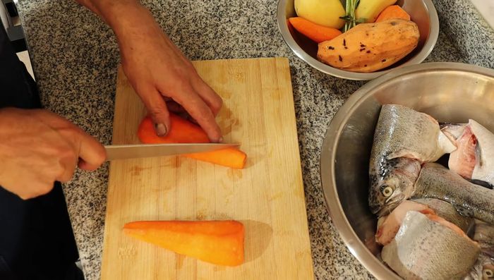 Cortar las verduras (col, repollo, zanahoria, papa, camote, choclo) en trozos medianos.
