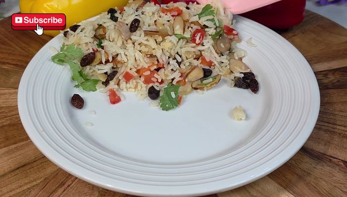 Agregar la mezcla de almendras, pasas y verduras a la sartén con el arroz.