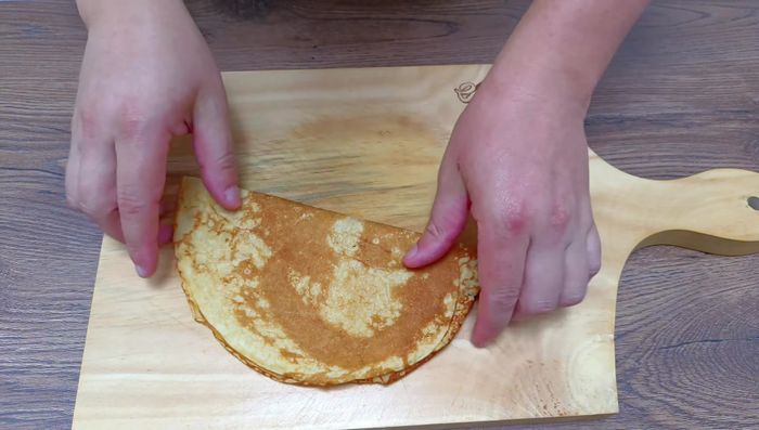 Doblar un crepe a la mitad. Agregar crema de avellanas a una mitad, esparcir con una espátula y agregar rodajas de plátano. Doblar nuevamente.