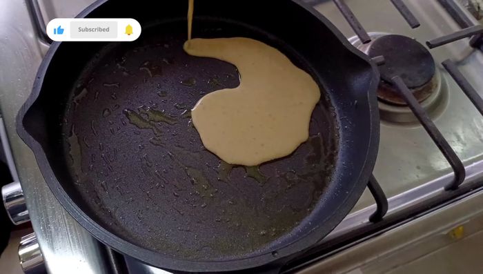 Calentar una sartén a fuego alto y untarla con aceite de oliva. Agregar una porción de la mezcla a la sartén, cubriendo toda la base.
