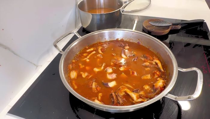 Añadir el agua (con la infusión de azafrán) y el caldo fumet. Tapar la olla y cocinar a fuego suave durante 30 minutos.