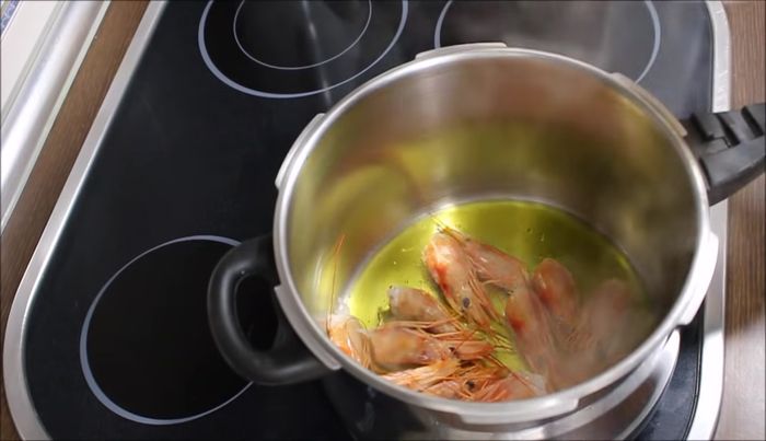 Echamos un chorrito de aceite generoso en la cazuela. Agregamos las cabezas de los gambones, la cabeza del calamar y la cabeza de la sepia. Freímos durante un par de minutos hasta que suelten el jugo.