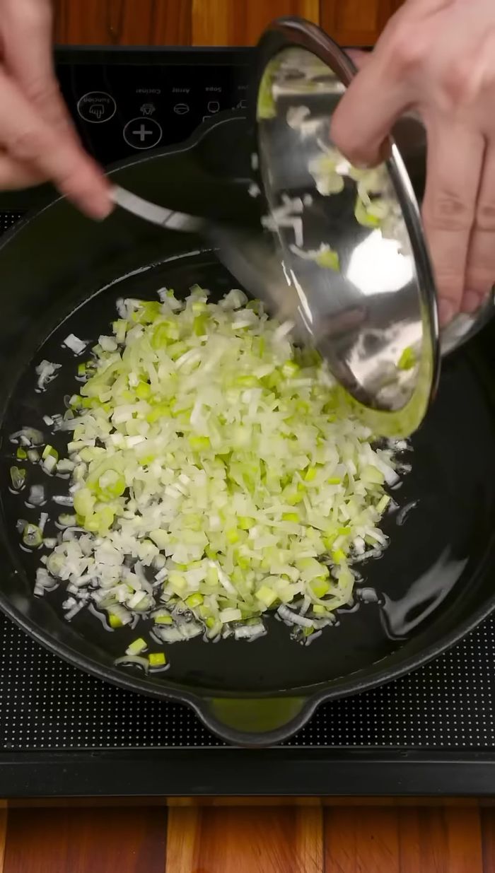 En una sartén, sofreír ajo, cebolla larga y tomate rallado con aceite, comino y sal. Cocinar unos minutos tapado.