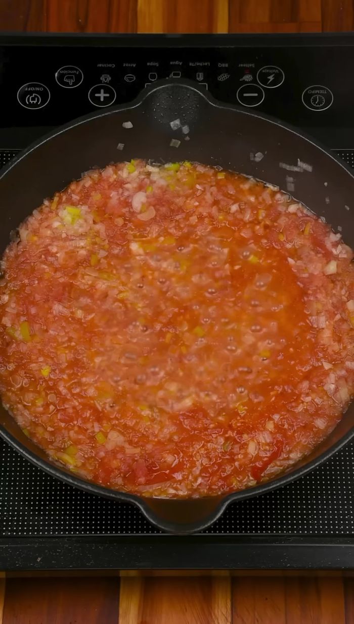 Agregar la carne desmechada de sobrebarriga, el verde de la cebolla larga y mezclar. Cocinar unos minutos.