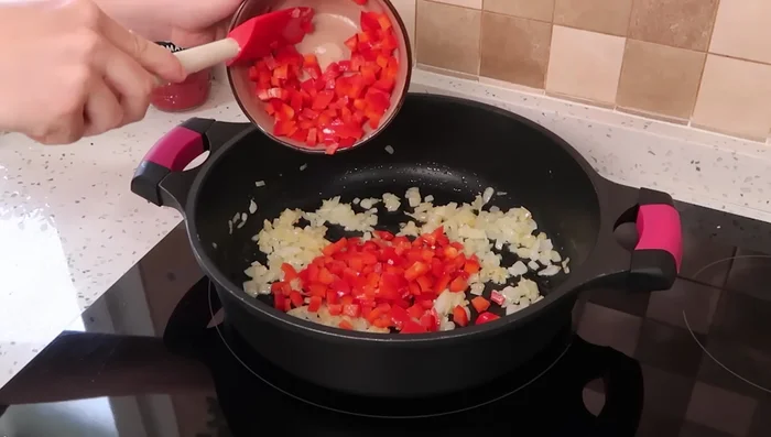 Echar un pimiento rojo cortado y cocinarlo junto a la cebolla.