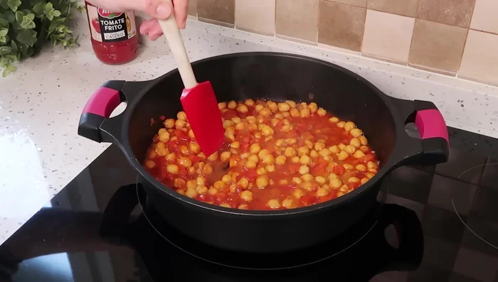 Hacer tres huecos entre los garbanzos, colocar un huevo en cada hueco y cocinar a fuego medio hasta que la clara cuaje.