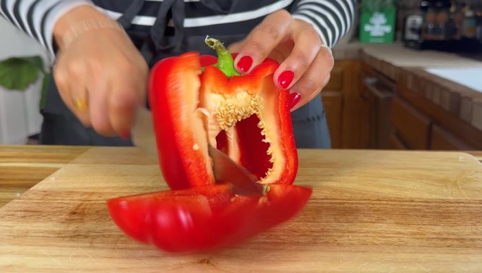 Cortar en cubitos la cebolla y el pimiento rojo. Cortar el chorizo en rodajas y los muslos de pollo en porciones.