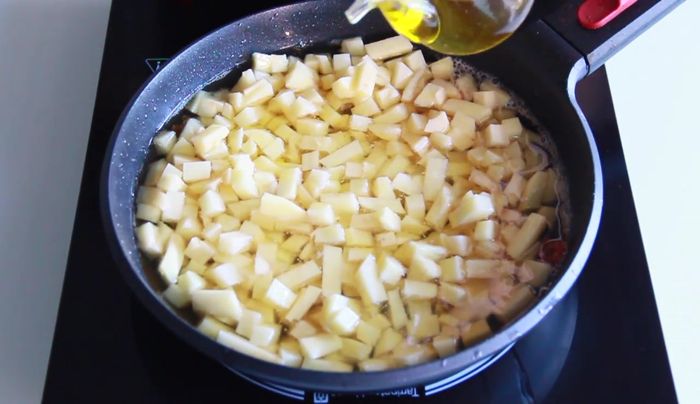 Freír las patatas en la misma grasa del pato a baja temperatura, añadiendo más aceite de oliva si es necesario. Tapar y cocinar hasta que estén confitadas, luego subir el fuego para dorarlas.