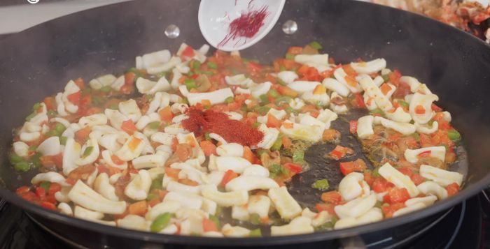 Incorporar una cucharadita de pimentón dulce, unas hebras de azafrán y dos tomates rallados. Mezclar y dejar cocinar a fuego medio durante 10 minutos.