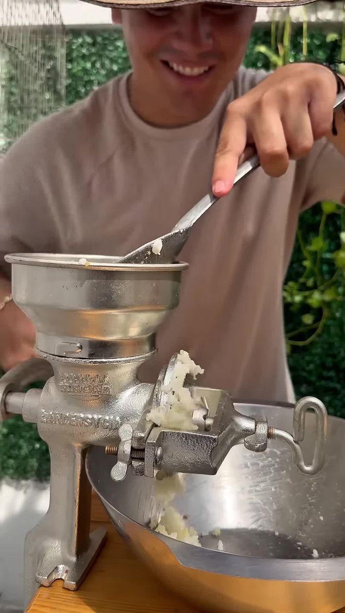 Moler el maíz cocido hasta obtener una masa suave (16.44).