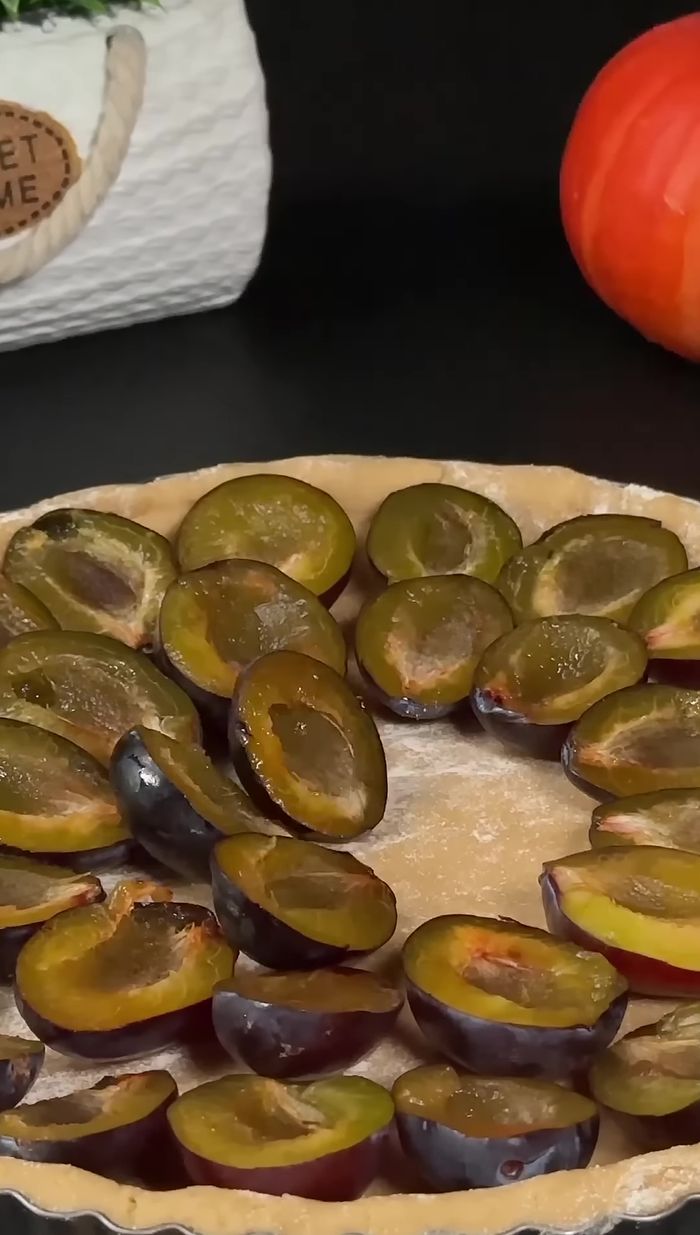 Colocar las ciruelas sobre la masa. Si están ácidas, espolvorear con azúcar.