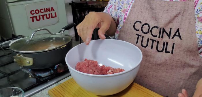 En un bowl, mezclar la carne de res y cerdo molida con sal, pimienta, un huevo, arroz previamente enjuagado y una parte del cilantro picado.