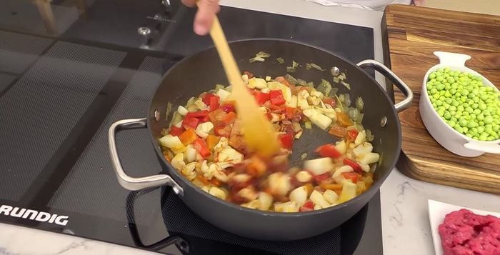 Añadir al guiso el tomate concentrado, el vino blanco y el caldo de pescado. Mezclar bien.