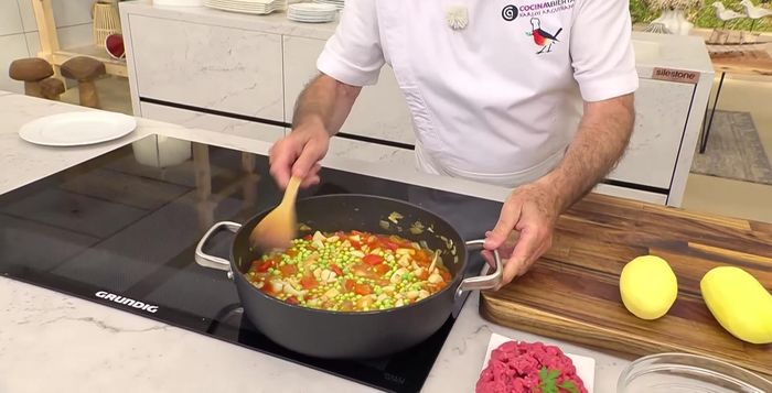 Incorporar los guisantes y las patatas troceadas al guiso.