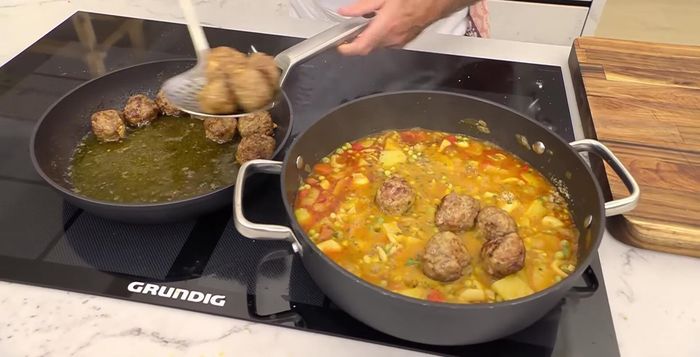 Añadir las albóndigas fritas y la picada al guiso. Cocinar a fuego lento durante 4-5 minutos más hasta que todo esté bien mezclado y las albóndigas estén cocidas.