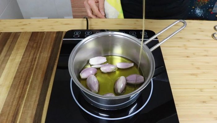 Confitar las chalotas: Ponerlas en un cazo cubiertas casi hasta arriba con aceite de oliva virgen extra. Cocer a fuego lento (mínimo) durante 20-30 minutos.