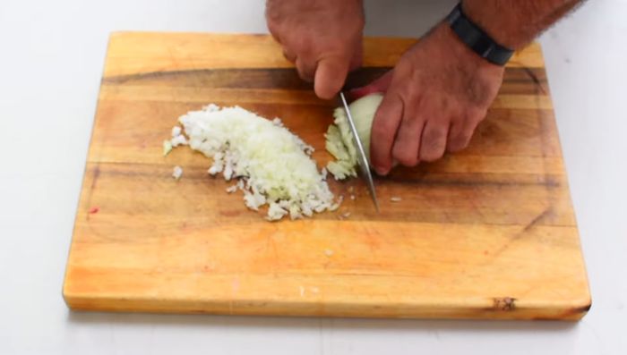 Picar finamente la cebolla y el tomate.