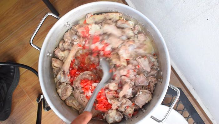 Agregar la cebolla y el tomate al cabrito y mezclar bien. Cocinar hasta que estén suaves.