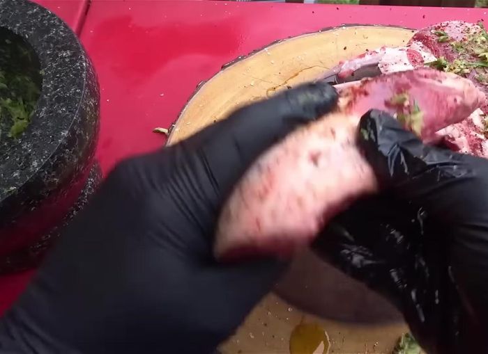 Untar la pasta de ajo y romero sobre el costillar, masajeando bien.