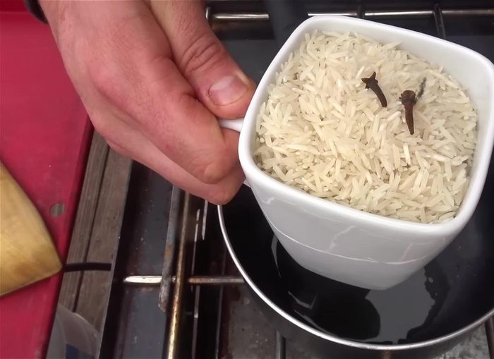 Preparar el arroz: dorar en una olla con aceite, clavos de olor, sal, pimienta y ajo granulado.