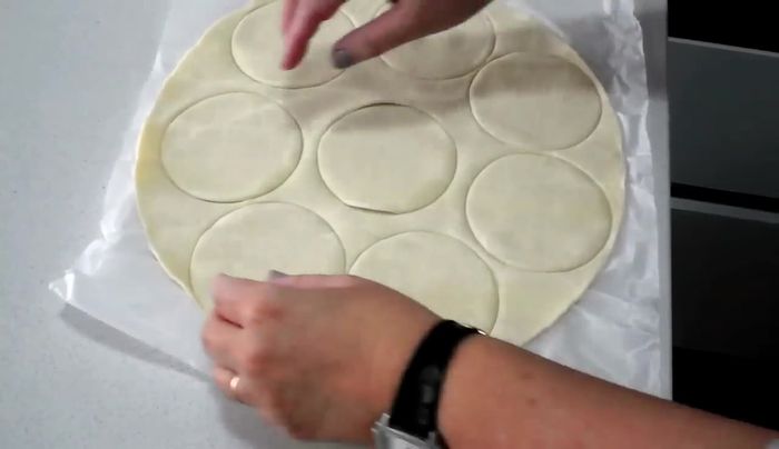 Cortar la plancha de hojaldre en círculos. Utilizar un molde más pequeño para hacer un círculo en el centro de cada uno. Quitar el sobrante de hojaldre.