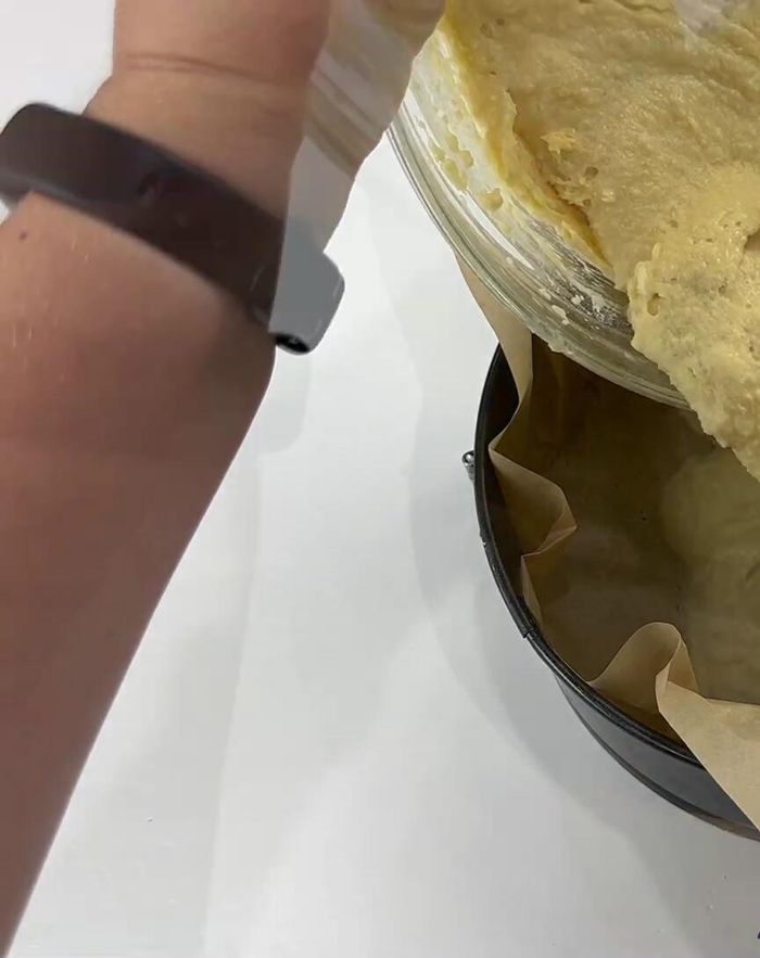 Transfiera la masa a un molde desmontable cubierto con papel pergamino. Distribuya uniformemente.