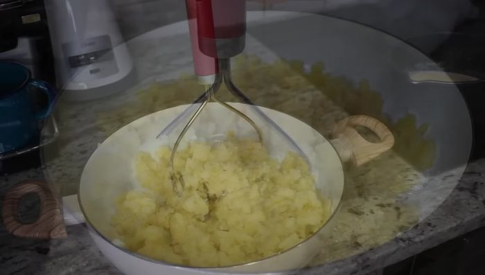 Agregar un poco de la leche tibia con mantequilla a las papas machacadas.