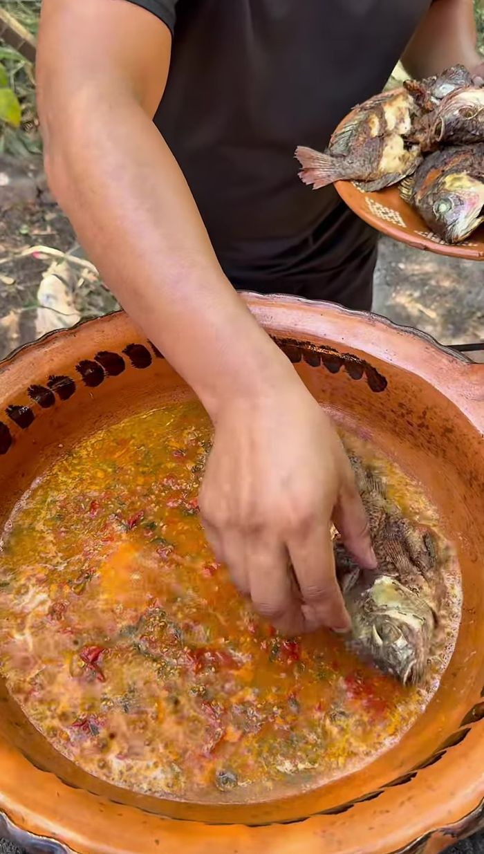 Agregar las mojarras fritas a la salsa, verter la salsa sobre las mojarras y dejar hervir aproximadamente 8 minutos.