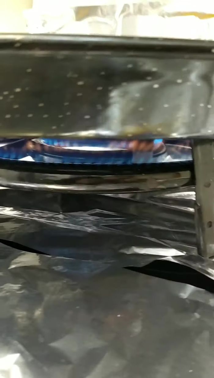 Distribuir el arroz de forma equitativa en la paella. Echar el caldo caliente (asegurarse de que esté suficientemente caliente para evitar que el grano se rompa).