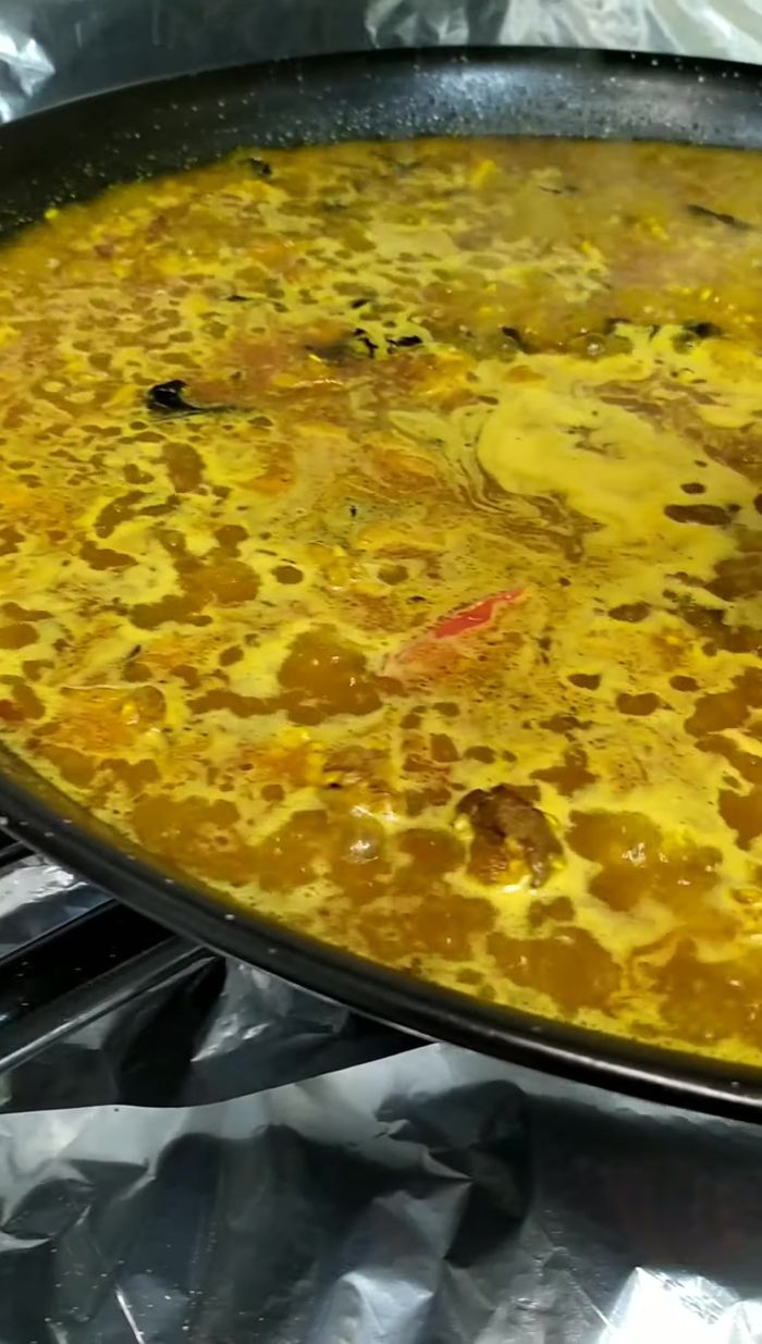 Cuando el arroz empiece a hervir, añadir el pimiento y la cebolla caramelizados.