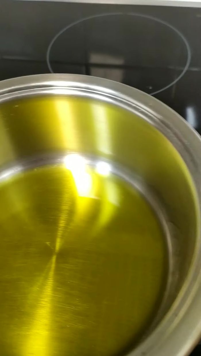 Cortar media cebolla y un pimiento rojo en tiras para caramelizar. En una cazuela con aceite de oliva, echar la cebolla y el pimiento, añadir sal.