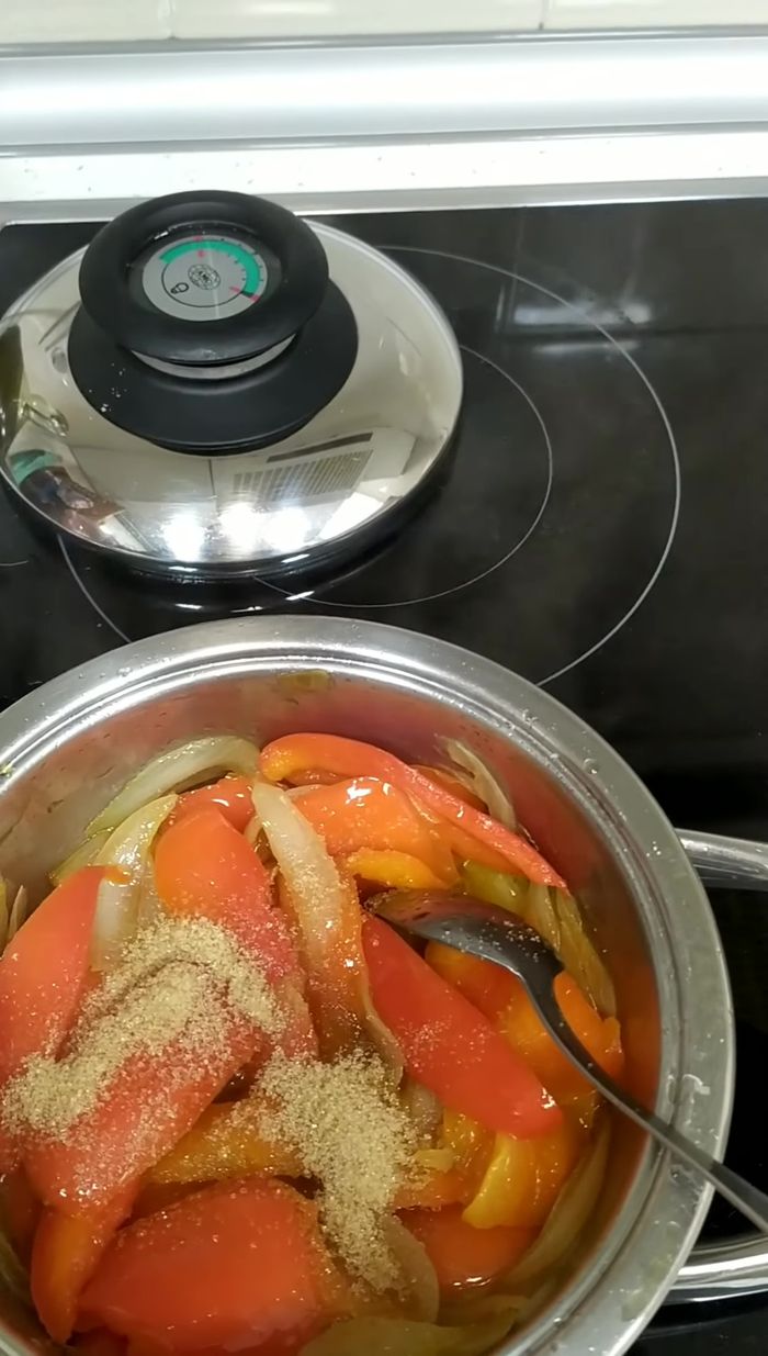 Añadir azúcar moreno y agua a la cazuela con la cebolla y el pimiento caramelizados. Remover y tapar. Cocinar durante 20 minutos aproximadamente.