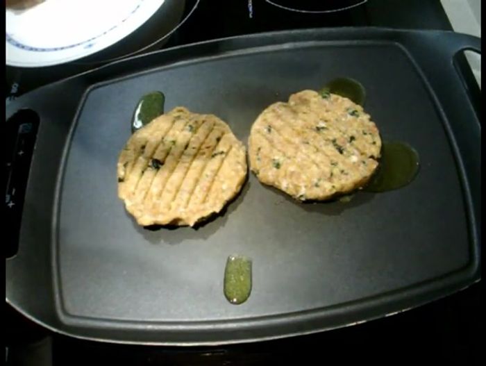 Una vez dadas la vuelta, añadir láminas finas de queso Manchego encima de cada hamburguesa.