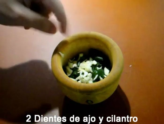 Majar en un mortero el cilantro y dos dientes de ajo.