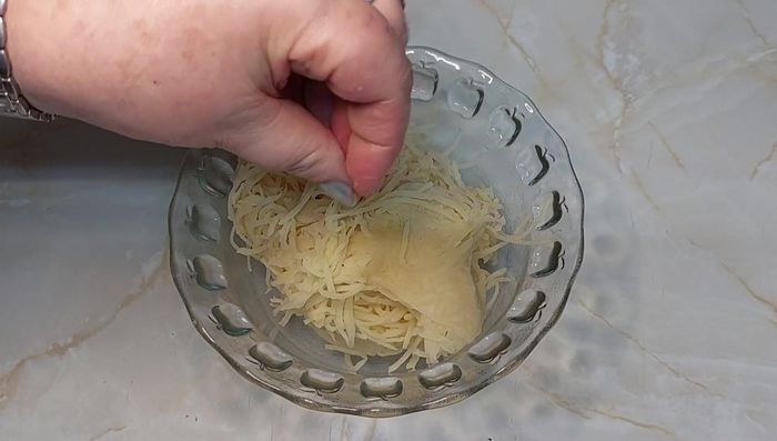 Apretar bien el paño para eliminar el exceso de agua. Agregar una pizca de sal y dos cucharadas de harina. Mezclar bien hasta que la patata esté compacta.