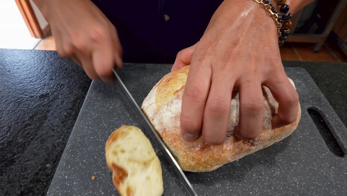 Hacer los crutones: cortar el pan en cubos pequeños. Mezclar mantequilla derretida con orégano y pimentón. Barnizar los cubos de pan con la mezcla y hornear a 180°C durante 12-15 minutos.