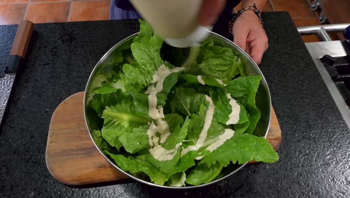 Armar la ensalada: mezclar la lechuga aderezada. Agregar el tocino triturado, crutones, queso parmesano, huevos de codorniz y anchoas adicionales (opcional). Decorar con la pechuga de pato.